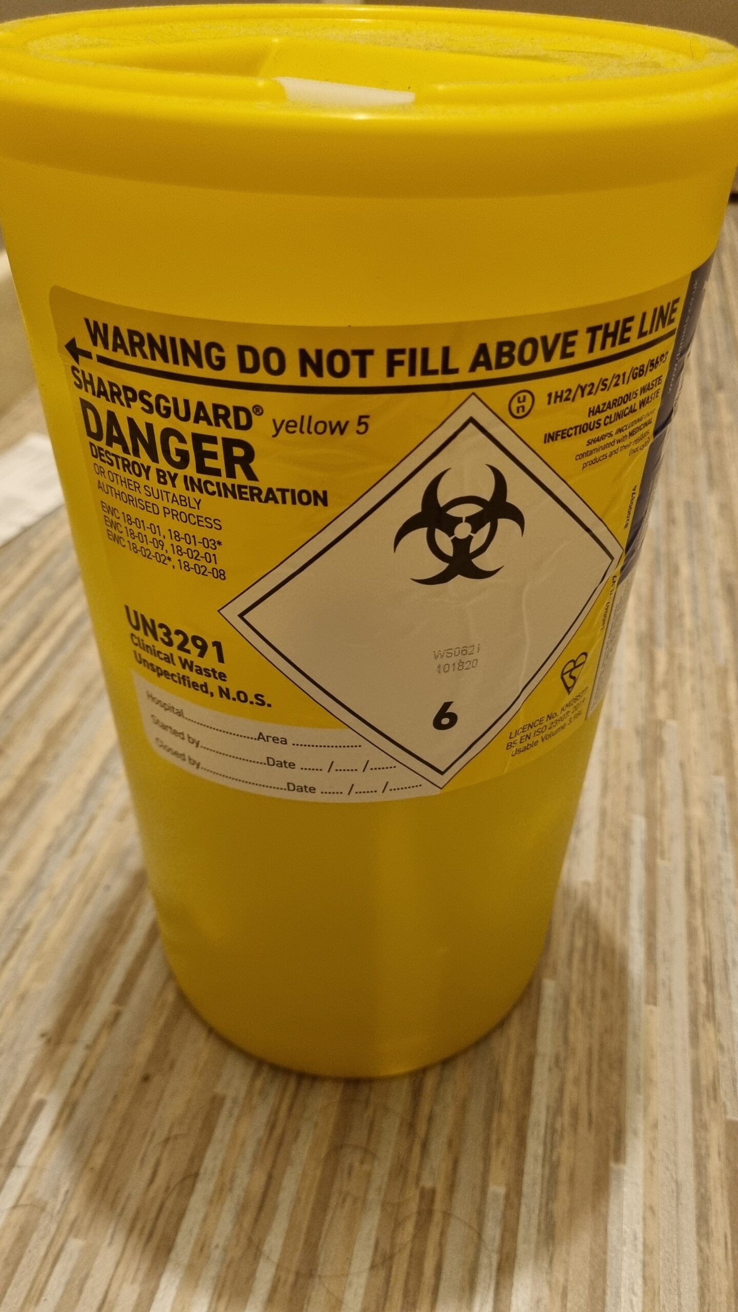 Yellow sharps bin for safely collecting used syringes