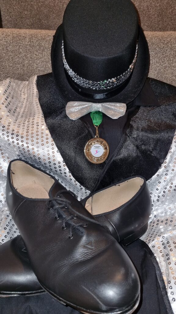 top hat with sequin band, sequin bow tie, sequin tail coat and tap shoes